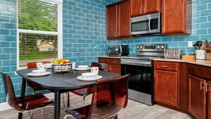 A kitchen with blue tiles, wooden cabinets, and modern appliances. - 

PerfectVacationHome5/4 Sleep12close to DisneyWorld, great forfamily gathering  (Kissimmee)