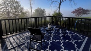 Un balcon doté d’un sol à motifs, d’une chaise, d’une table et d’une plante en pot.