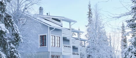 Ein mehrstöckiges Gebäude im modernen Stil, umgeben von schneebedeckten Bäumen.