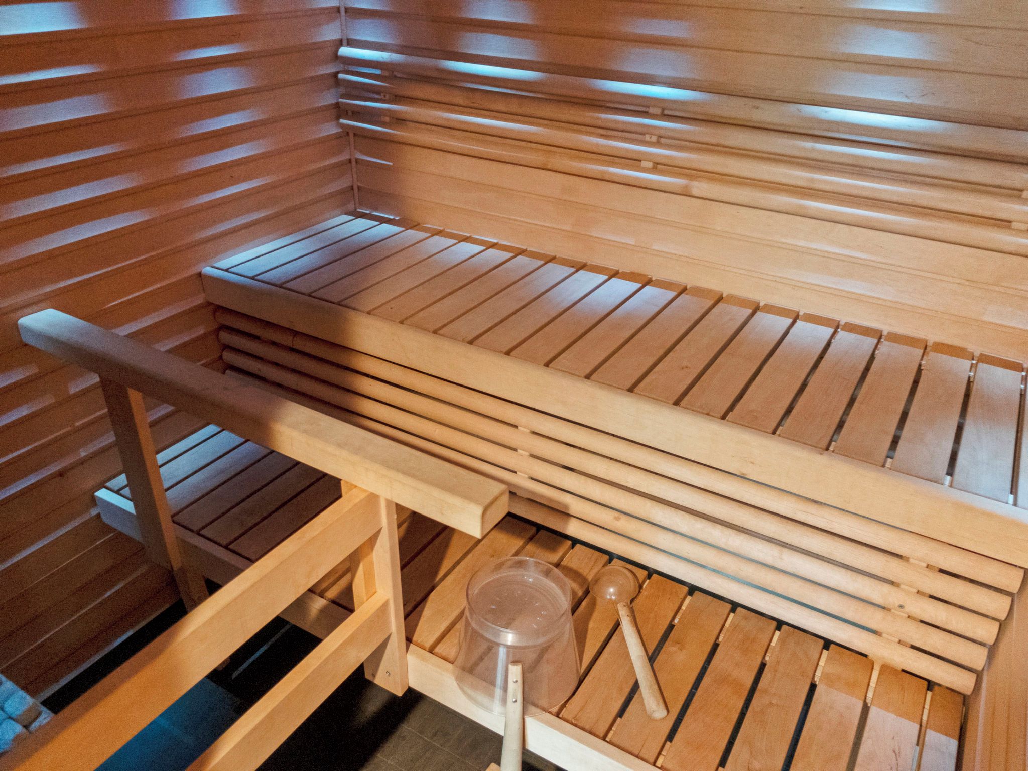 A wooden sauna bench with a bench seat and a lower shelf.