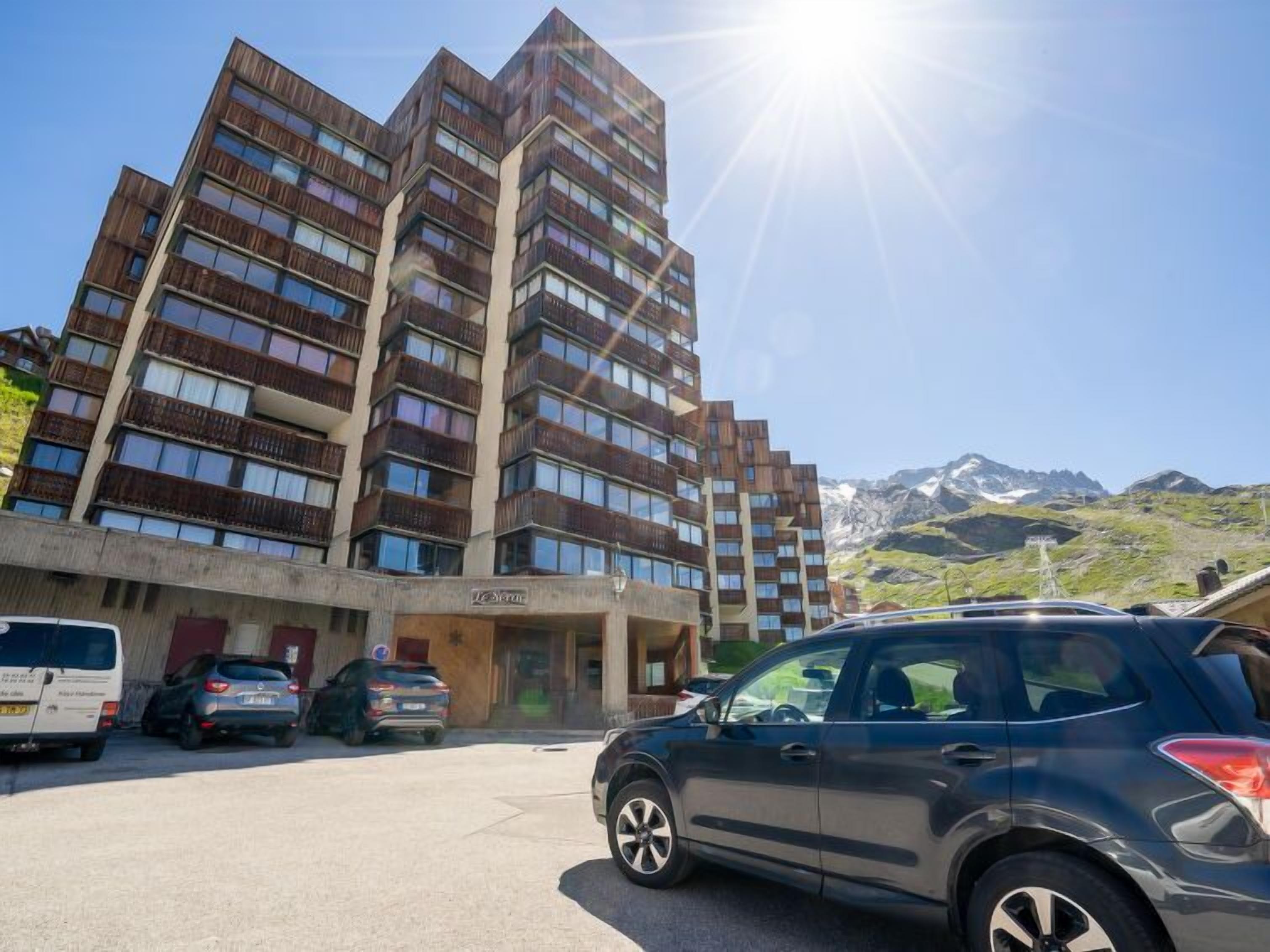 A multi-story hotel with a modern design, featuring balconies on each floor.