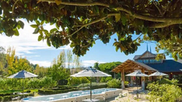 A pool area with a hot tub, umbrellas, and outdoor seating. - Pinschower Inn (Cloverdale)