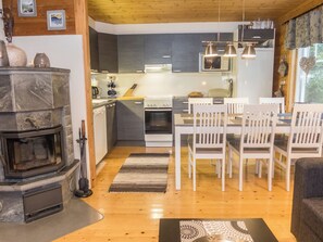 A modern kitchen with a central island, white chairs, and a dining table. - Karpalo by Interhome (Kuusamo)