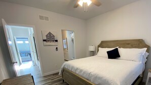 Ein Schlafzimmer mit einem hölzernen Bett, weißer Bettwäsche, einem Nachttisch und einer Holzbank.