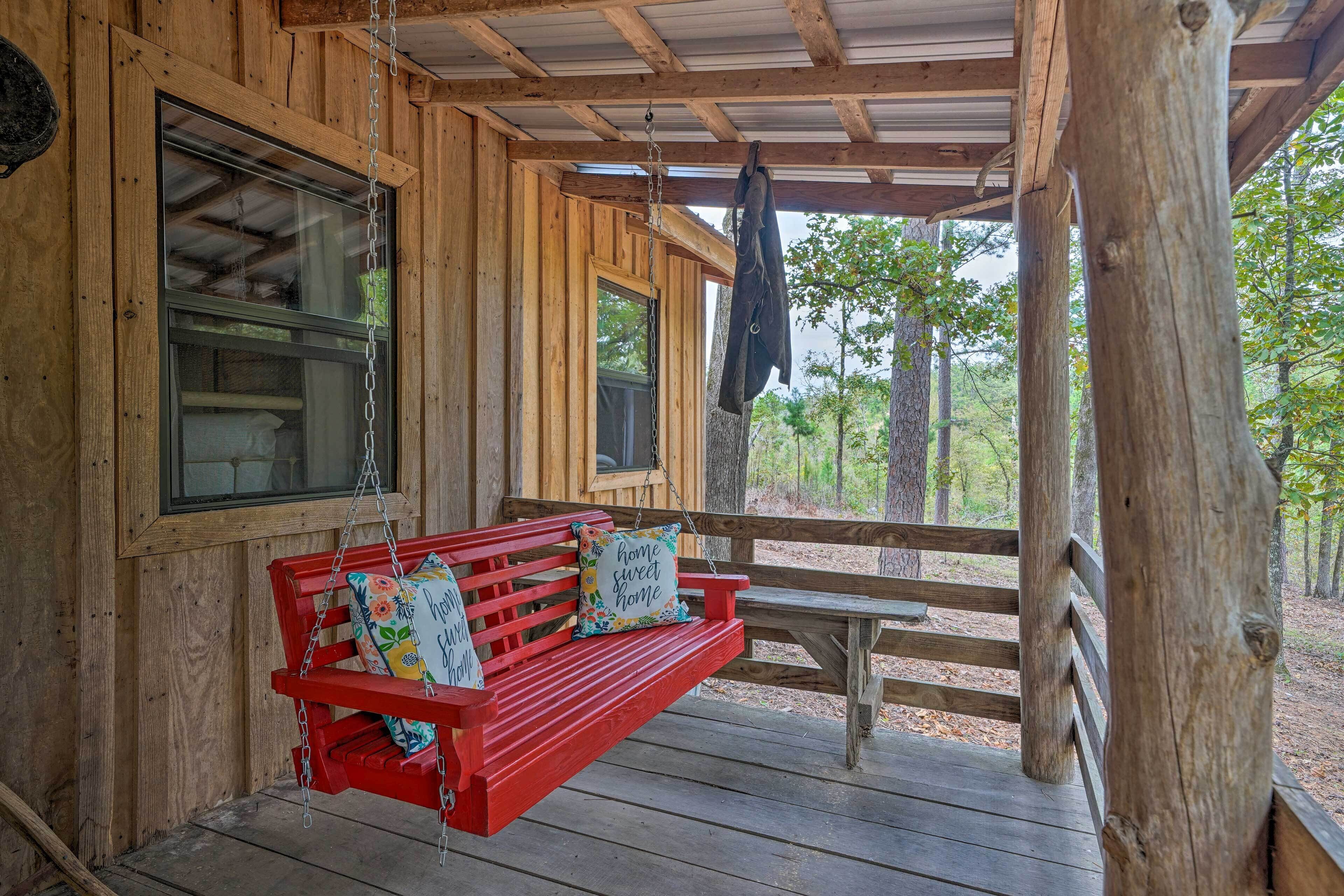 A wooden cabin with a red bench and a hanging coat rack.