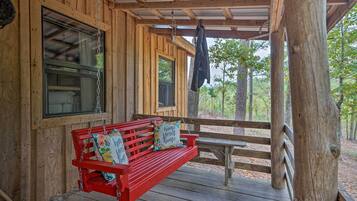 A wooden cabin with a red bench and a hanging coat rack.