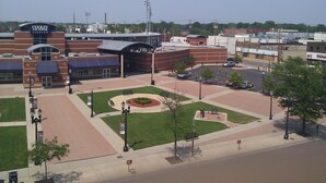 A Cooley Law School building with a parking lot, green lawns, and a few trees. - Luxury Condo downtown Lansing (Lansing)