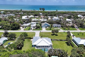 A coastal residential area with houses, a swimming pool, and a view of the ocean.