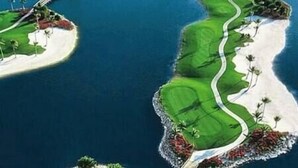 A golf course with a winding path, sand bunkers, and palm trees. - Greenlinks Luxury Condo, 3BD, ground floor, golf, pool (Naples)