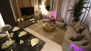 A modern living room with a round coffee table, sofa, and TV. - SLV Smart Living Villa (دبيdubai)