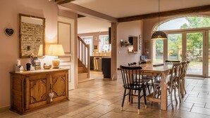Cucina spaziosa con zona pranzo, mobili in legno e un'ampia finestra che offre vista sull'esterno.