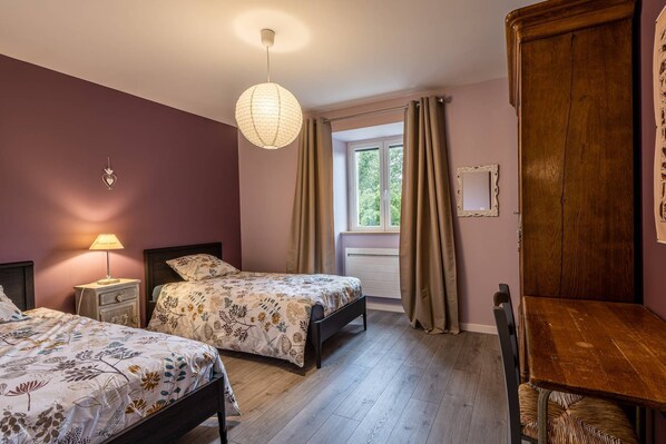 A bedroom with two beds, a wooden wardrobe, a desk, and a hanging light fixture. - Old farmhouse, renovated in 2021, 4-star, charming, relaxation in the heart of nature (Lizine)