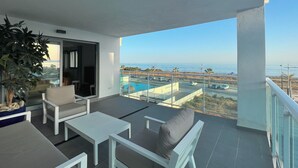 A balcony with a sofa, chairs, and a table.