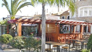 A restaurant with outdoor seating, a pergola, and a sign for Waldemar's International. - Apartment with Large Roof Solarium, Pool, Garden, Barbecue, A/C & Wi-Fi (Orihuela Costa)