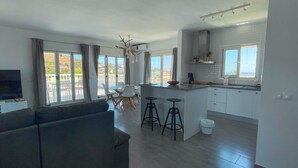 A modern apartment with a living room, kitchen, and dining area. - Apartment "Atico Montesol" with Sea View, shared Pool & Terrace (Torrox Costa)