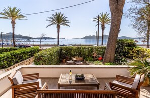 Eine Terrasse mit Tisch, Stühlen und Meerblick.
