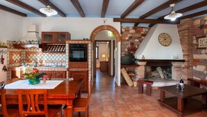 A spacious kitchen with a dining area, a fireplace, and a TV.