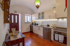 A kitchen with white cabinets, a stainless steel dishwasher, a microwave, and a tiled backsplash. - Villa 'Oliva AL' with Nature Views, Pool, Garden, Terrace, Wi-Fi & AC (Moncarapacho)