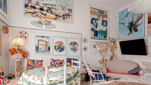 Ein Zimmer mit einem runden Tisch, einer Couch und verschiedenen Kunstwerken an den Wänden.