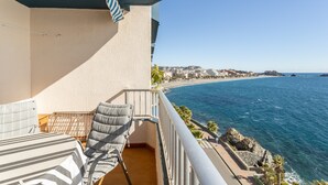 A balcony with a view of the sea, a chair, and a small table. - Apartment with Sea View, Balcony, and Air Conditioning (Almunecar)