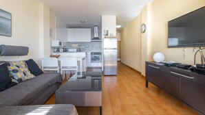 A modern apartment with a living area, kitchenette, and a flat-screen TV. - Apartment with Sea View, Balcony, and Air Conditioning (Almunecar)