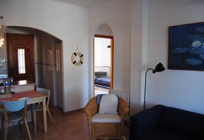 A compact living space with a kitchenette, dining area, and a sofa.