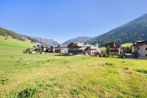 A rural village with traditional houses, a clear sky, and mountains in the background. - 'Appartamento 8' with Mountain View, Shared Garden & Wi-Fi (Livigno)