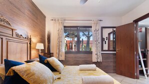 Une chambre d’hôtel avec un lit, une table de chevet, une lampe et une vue sur l’extérieur.
