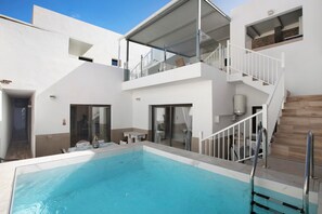 Un edificio moderno con piscina, escalera y balcón.