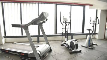 A gym with a treadmill, elliptical, and stationary bikes.