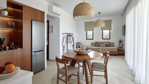 A modern kitchen with a built-in refrigerator, wooden cabinets, and a dining area with a round table and chairs.