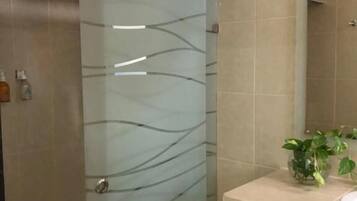 Suite superior, 1 cama King size y sofá cama, cocineta | Baño | Regadera, regadera tipo lluvia, toallas, jabón