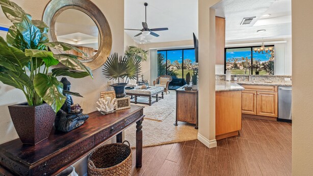 A spacious living area with a large mirror, wooden furniture, and a view of the outdoors. - PGA West 3Bed Golf Mountain and Course View Home (La Quinta)
