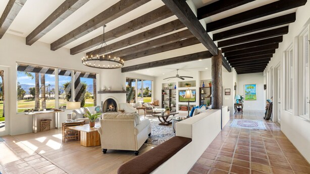 A spacious living area with a fireplace, large windows, and a view of the outdoors.