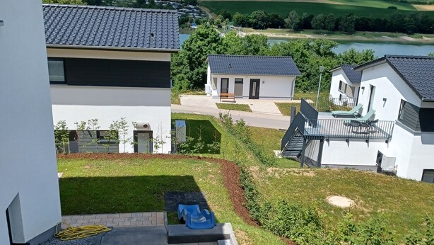 Zona residencial con casas modernas, un césped y vistas a colinas onduladas.