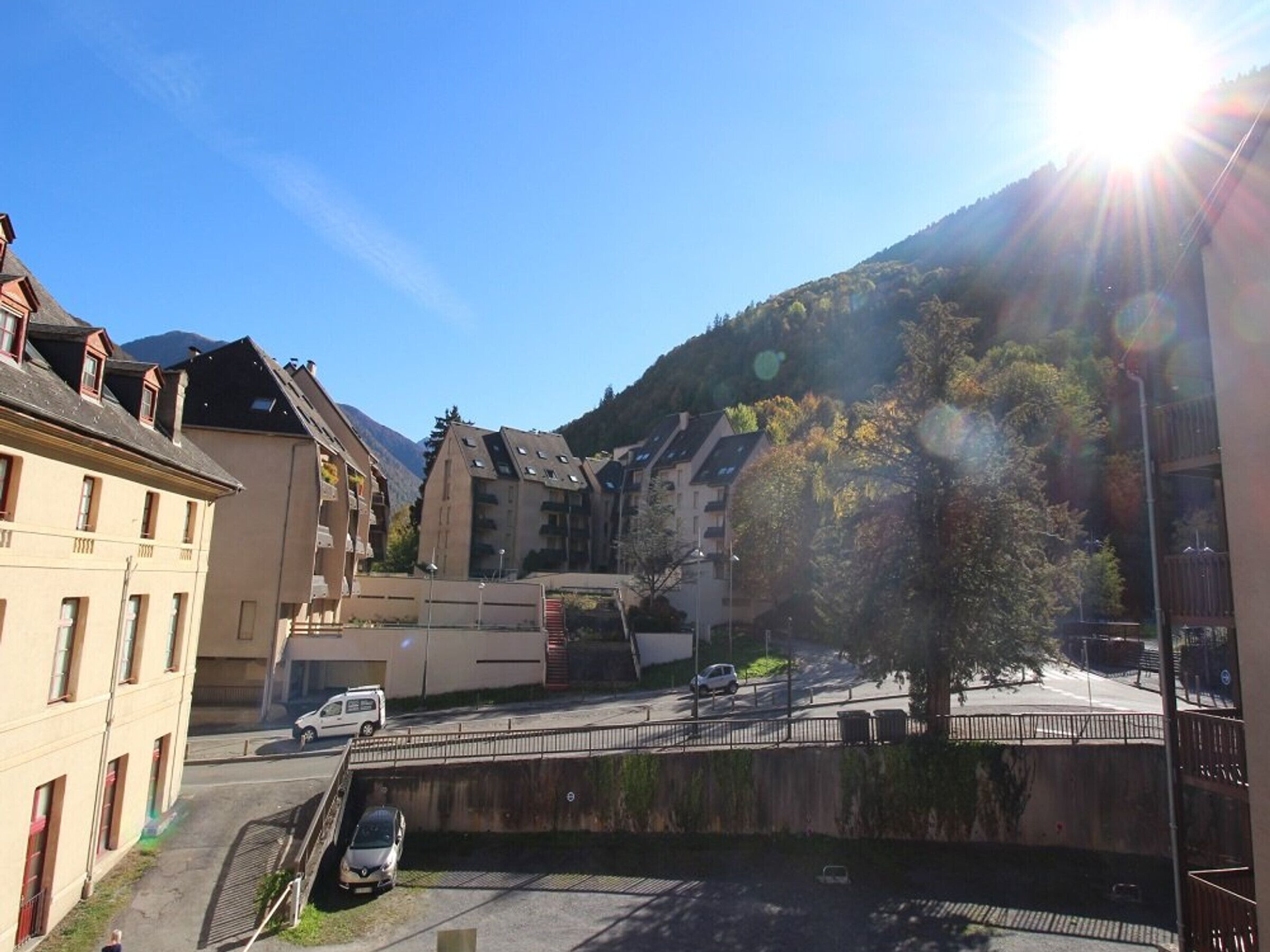 A residential area with multi-story buildings, a bridge, and a mountain backdrop.