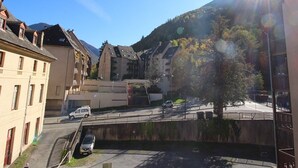 A residential area with multi-story buildings, a bridge, and a mountain backdrop.