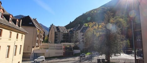 A residential area with multi-story buildings, a bridge, and a mountain backdrop.