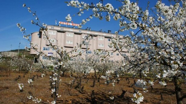 A hotel with a sign reading "HOTEL NOVA" and a building with multiple windows and balconies. - Hotel Novo (Ponferrada)