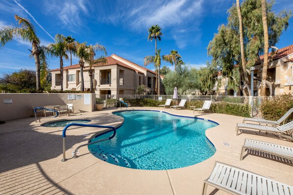 A swimming pool with lounge chairs and palm trees. - **NEW** Beautiful Racquet Club Condo (Scottsdale)