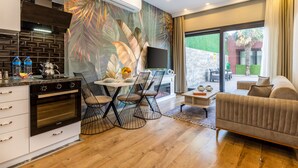 Una cocina moderna con comedor, televisor de pantalla plana y sofá.