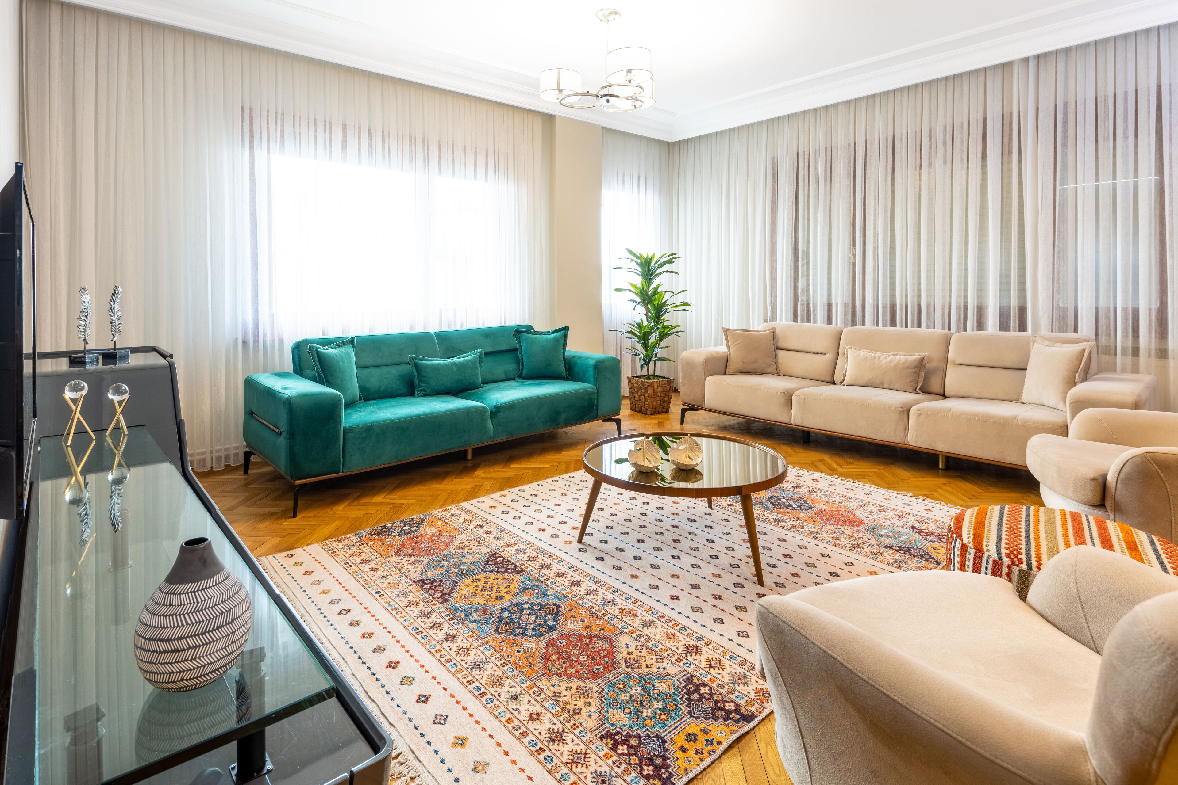A living room with two sofas, a coffee table, a TV stand, and a patterned rug.