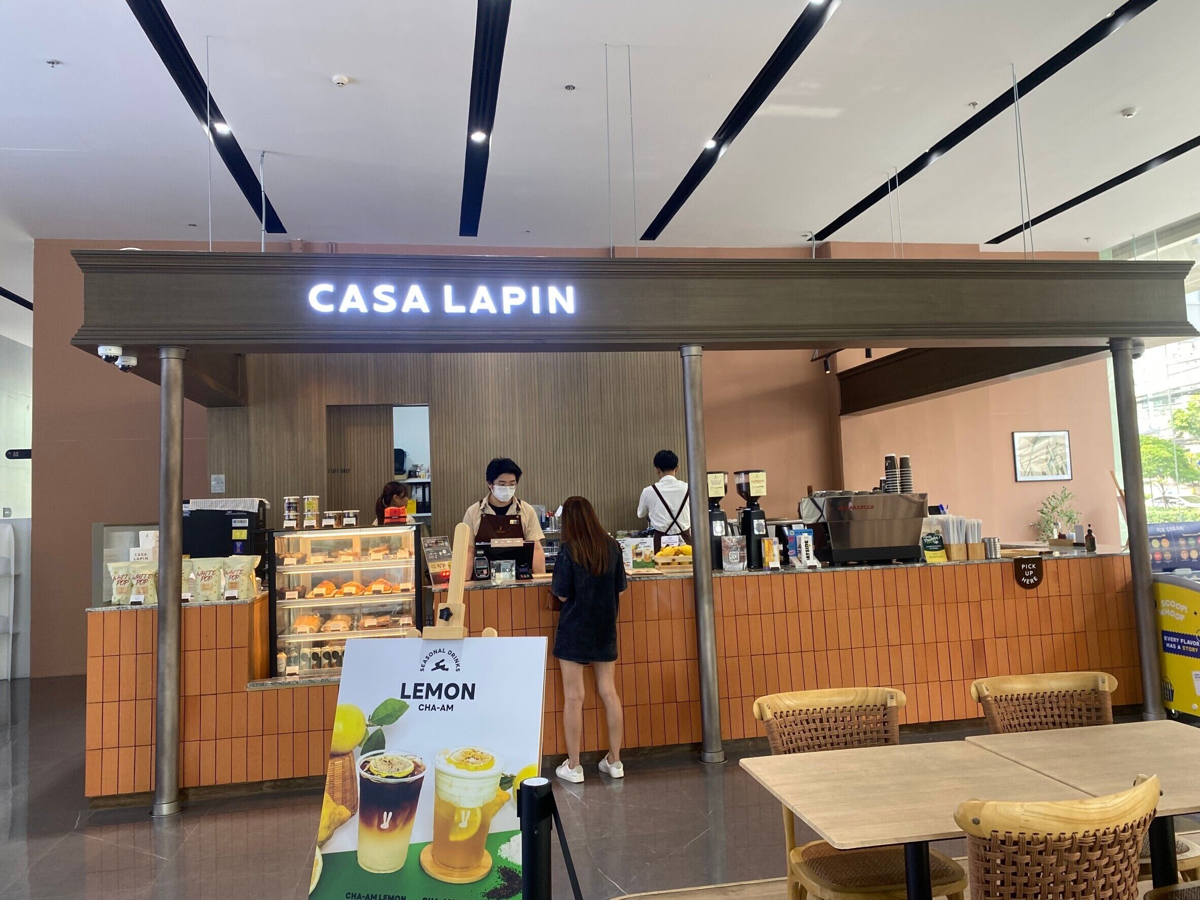 Un café appelé « Casa Lapin », avec un comptoir, du personnel et un tableau affichant le menu.