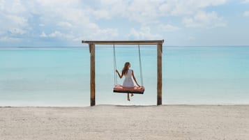 Trên bãi biển, cát trắng, nhà lều trên biển, ghế dài tắm nắng