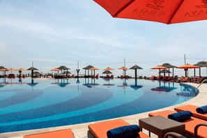A swimming pool with lounge chairs and umbrellas, surrounded by a tiled deck. - Al Maya Island & Resort (Abu Dhabi)