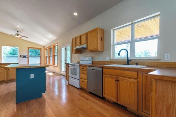 Enjoy cooking in this well-equipped kitchen with a central island, oven, and stainless steel sink.