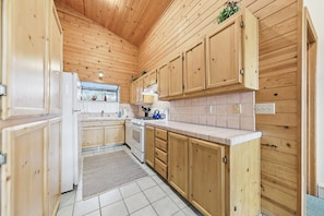 A kitchen with wooden cabinets, a stove, and a refrigerator.
