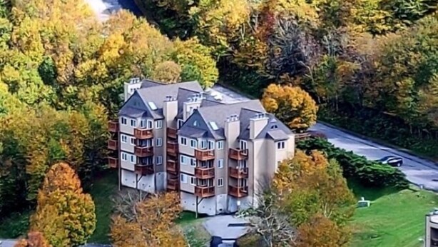 Un immeuble résidentiel à plusieurs étages, doté d’une façade symétrique, de nombreux balcons et d’une cour intérieure.