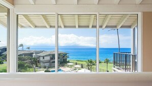 Un balcon avec vue sur l’océan et une zone résidentielle.
