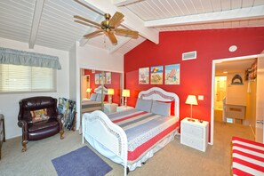 A bedroom with a bed, a chair, a ceiling fan, and a red wall. - 315CE: 3B 2B CART, WIFI, BBQ (Avalon)